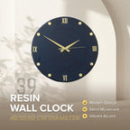 A navy blue resin wall clock with gold-colored hands and hour markers. The clock face features Roman numerals and the text "ART STUDIO 39 RESIN WALL CLOCK 40,50,60 CM DIAMETER". The clock has a modern design and silent movement.