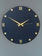 A round, navy blue wall clock with gold-colored Roman numerals and hands. The clock face has gold-colored dot markers. The text "ART STUDIO 29" is printed on the clock face.