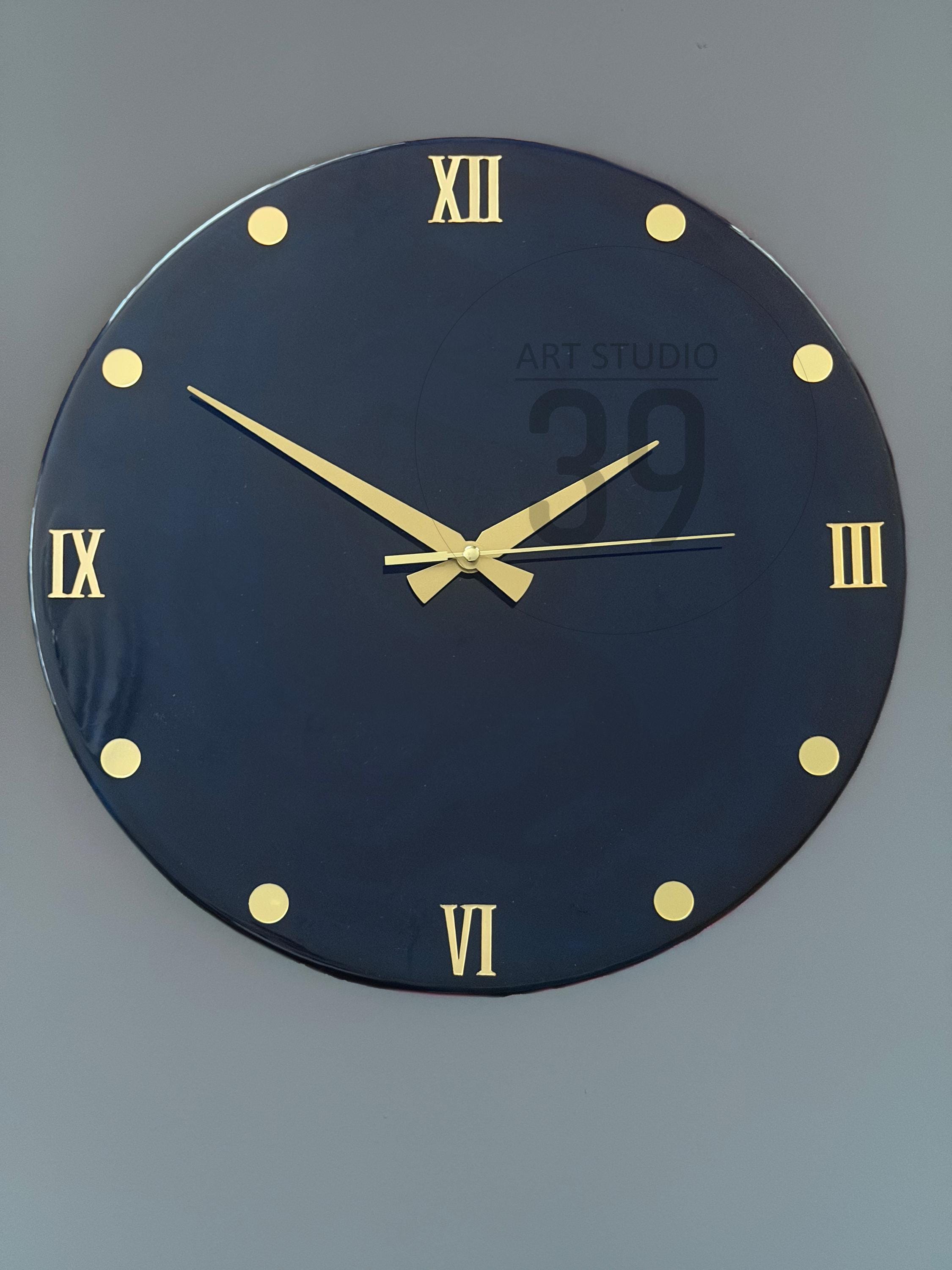 A round, navy blue wall clock with gold-colored Roman numerals and hands. The clock face has gold-colored dot markers. The text "ART STUDIO 29" is printed on the clock face.