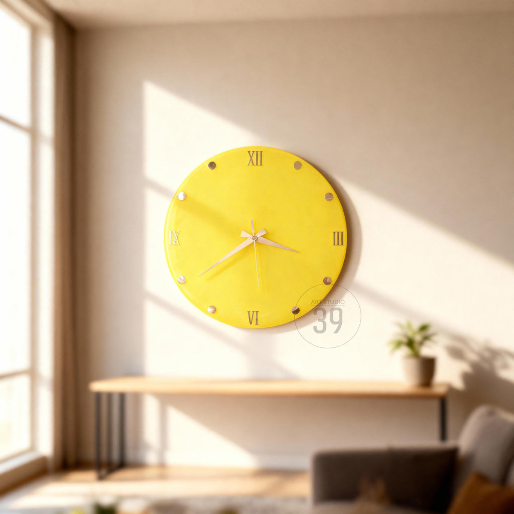 A round, yellow wall clock with Roman numerals and silver accents. The clock hands are silver, and the clock is mounted on a white wall. The clock is approximately 12 inches in diameter.