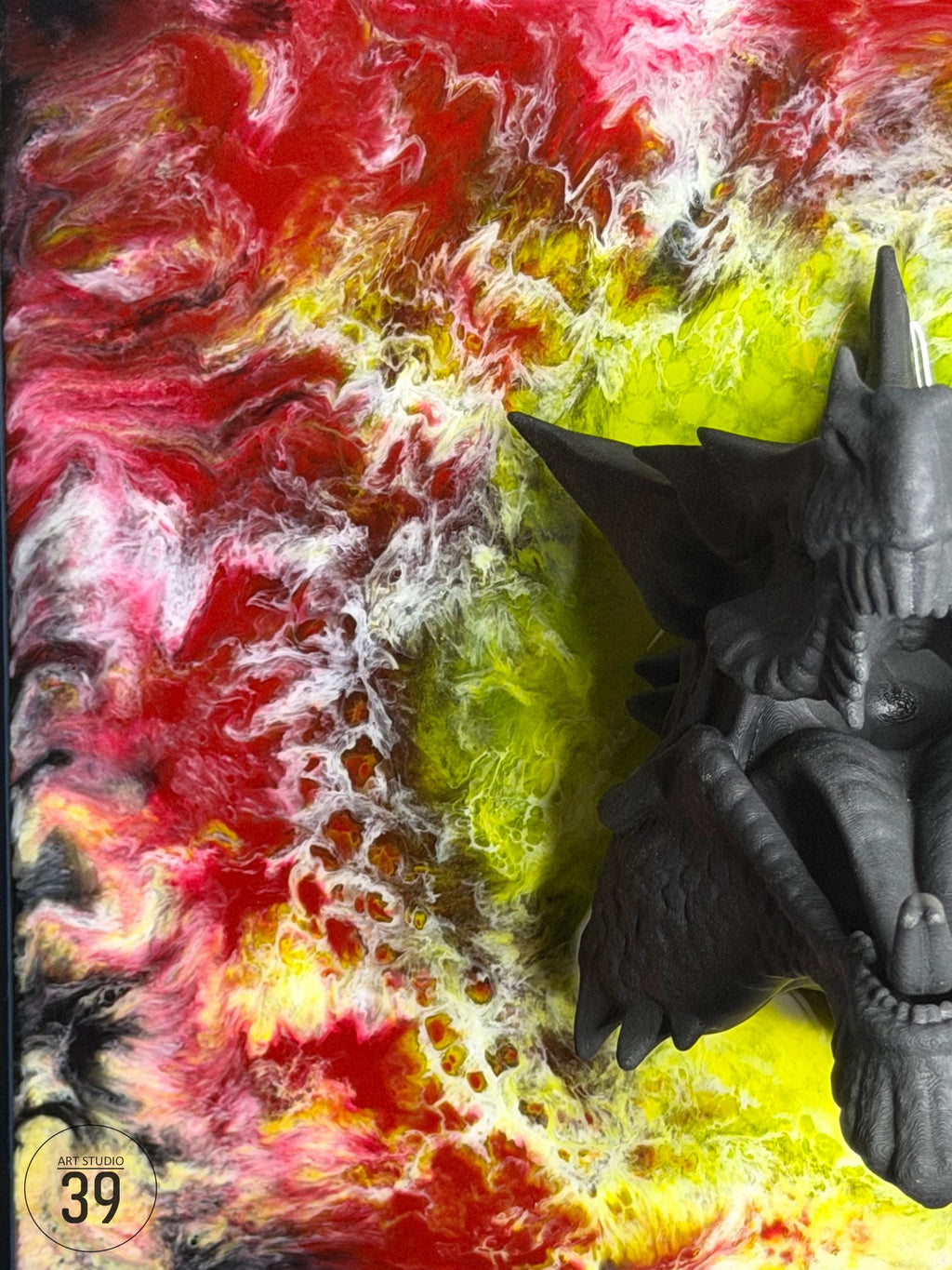 Abstract artwork with a vibrant background of swirling red, yellow, and white colors. A detailed, gray, three-dimensional sculpture of a creature is positioned on the right side. The artwork is signed "ART STUDIO 39".