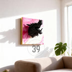 A black dragon head sculpture mounted on a pink and gold abstract art piece. The artwork is framed with a gold border and hangs on a white wall. The text "ART STUDIO 39" is in a circle below the artwork.