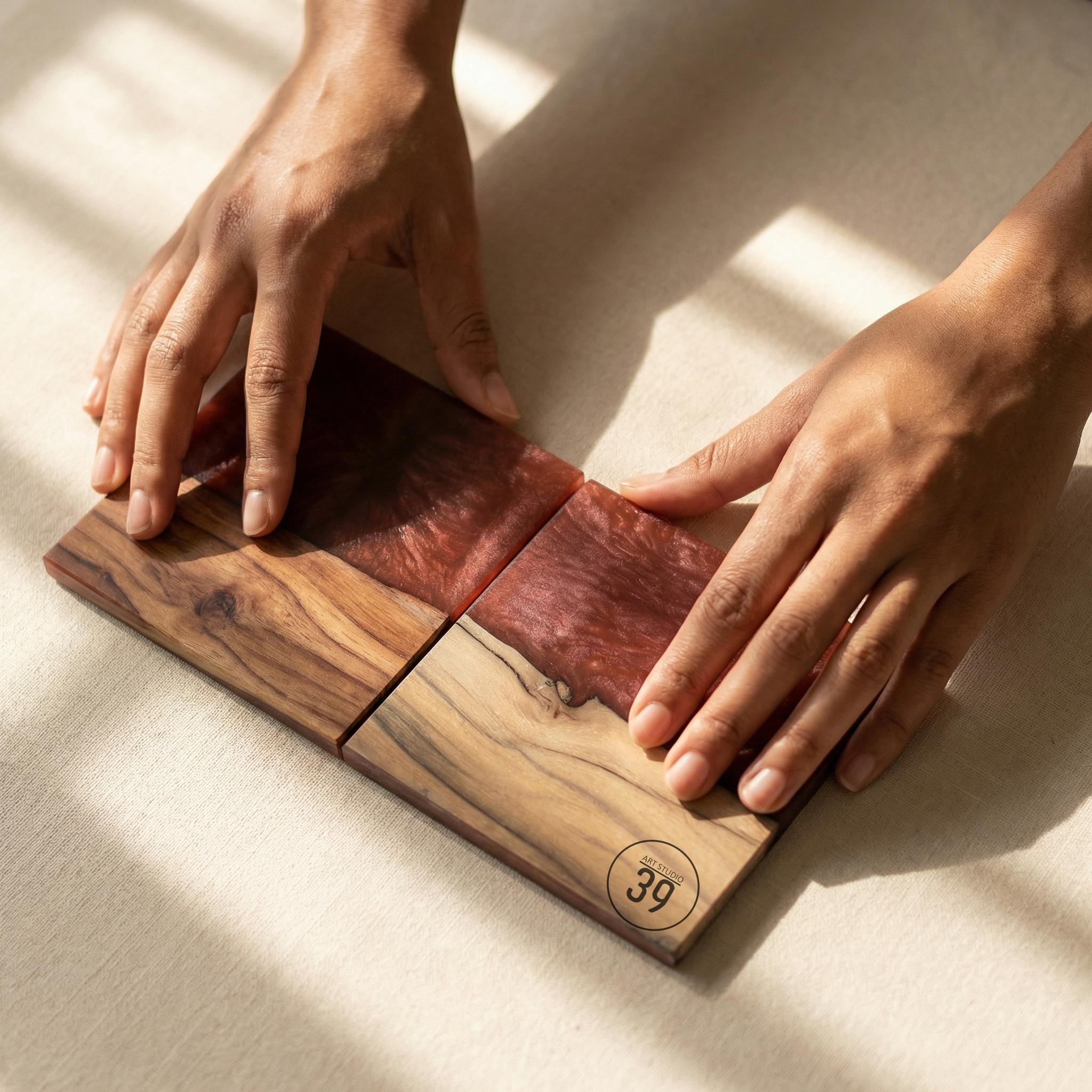 Four-piece wooden coaster set with a unique design. Two coasters feature a light wood grain, while the other two have a deep red resin inlay. The coasters are square and appear to be handmade. The number "39" is printed on one coaster.