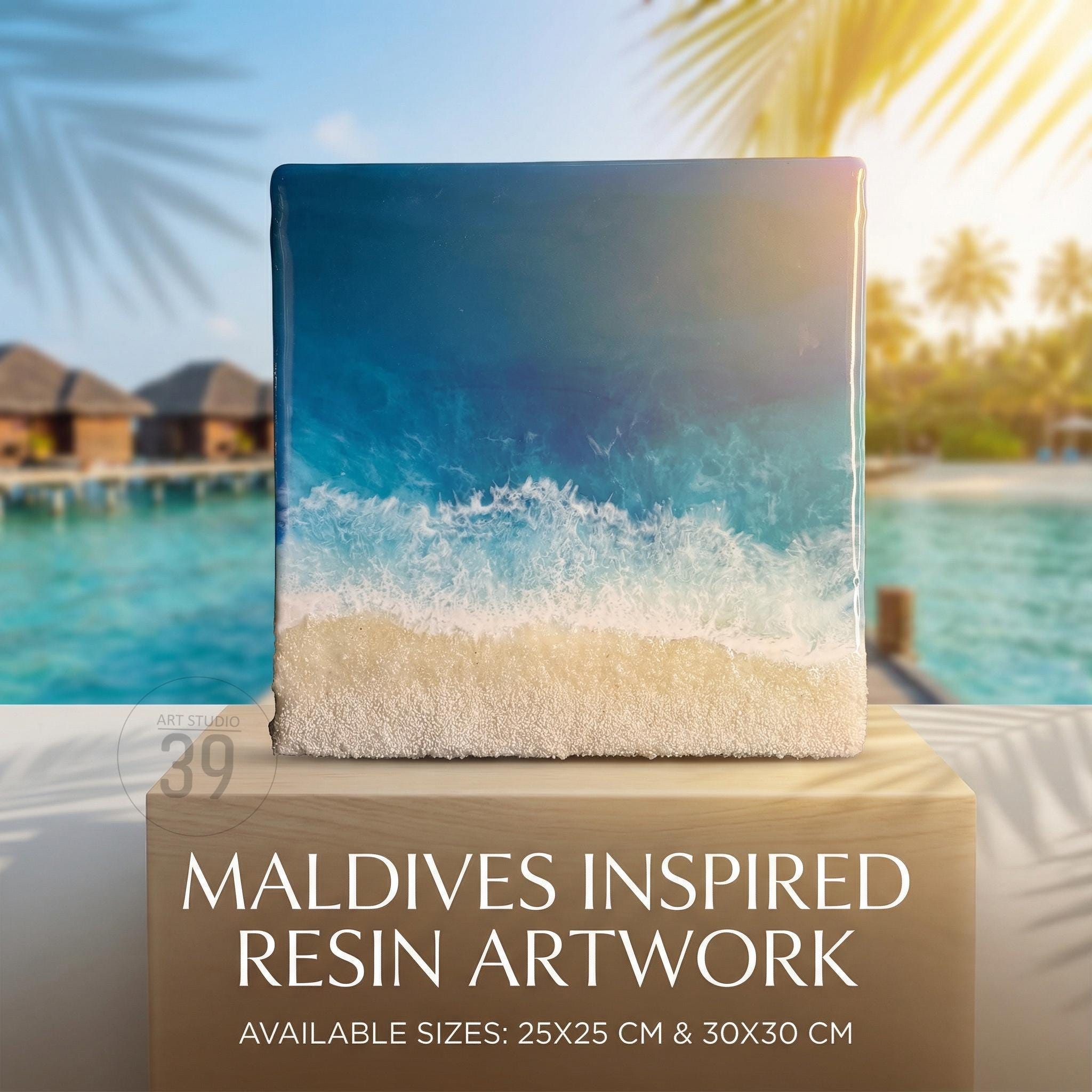 Square resin artwork depicting a beach scene with blue ocean waves and a sandy shore. The artwork is inspired by the Maldives and is available in 9.8 x 9.8 inch and 11.8 x 11.8 inch sizes. The text "MALDIVES INSPIRED RESIN ARTWORK" is displayed.