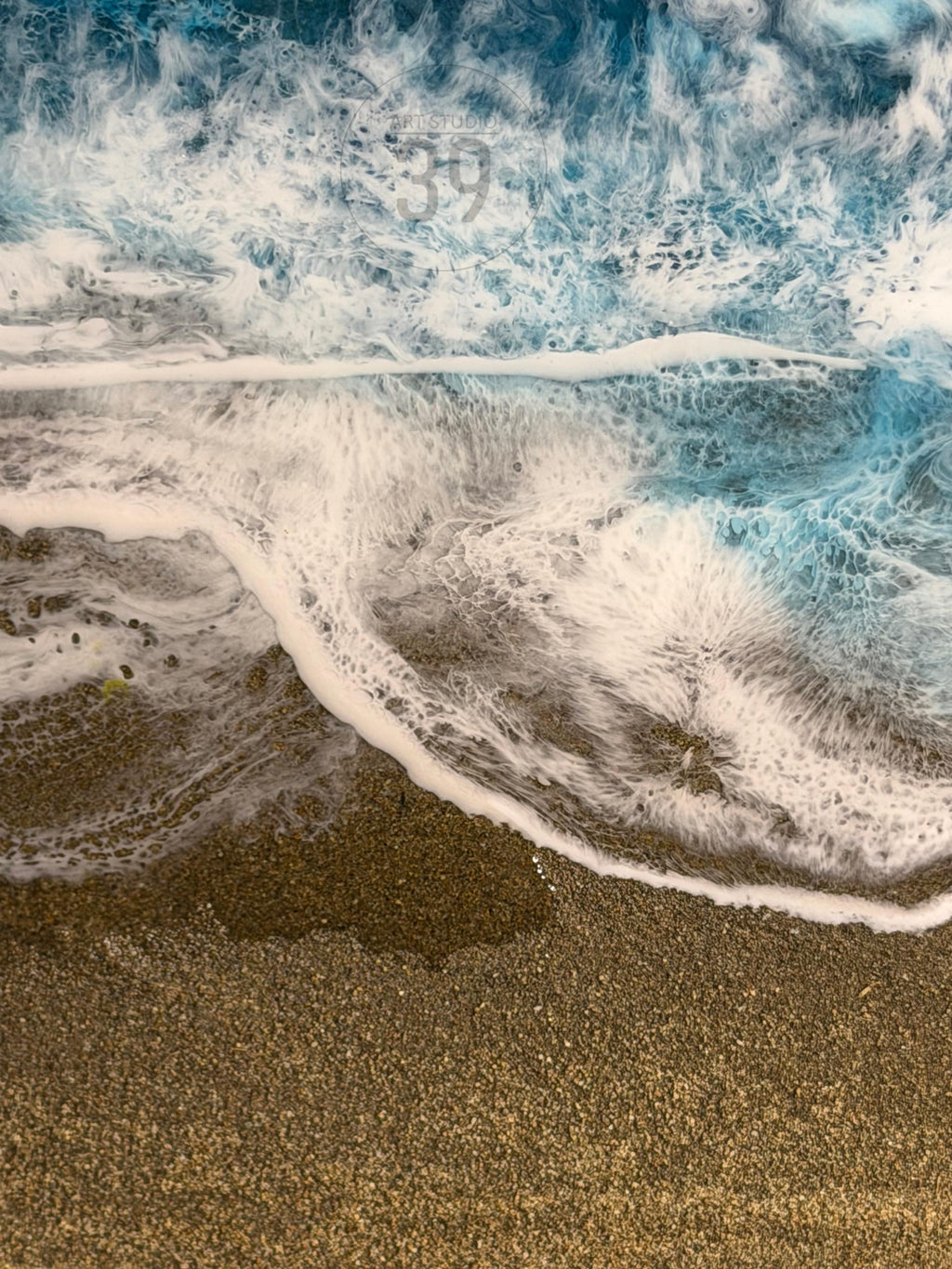 Abstract artwork depicting a beach scene with foamy white waves crashing onto a sandy shore. The water transitions from deep blue to white, with the sand appearing in shades of brown and tan. The number "39" is visible in the upper right corner.