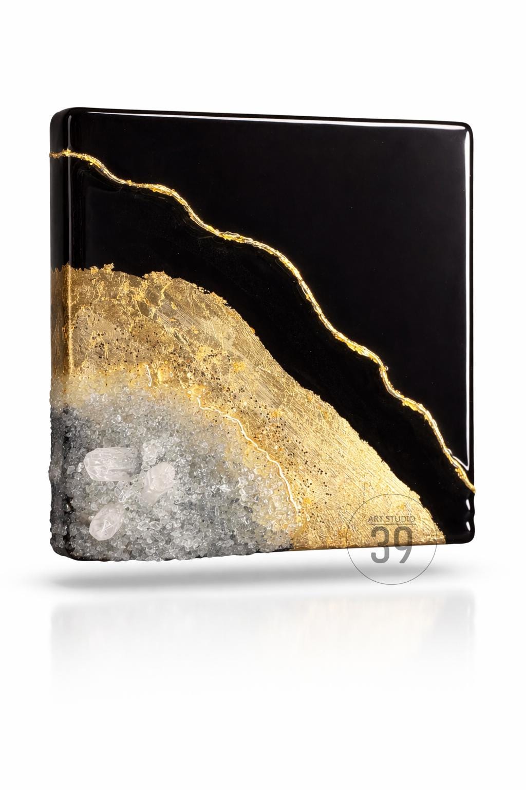 Square resin art piece with a black background, gold leaf accents, and a textured, crystal-like base. The gold leaf forms a diagonal line across the black surface. The bottom edge features a rough, crystal-like texture.