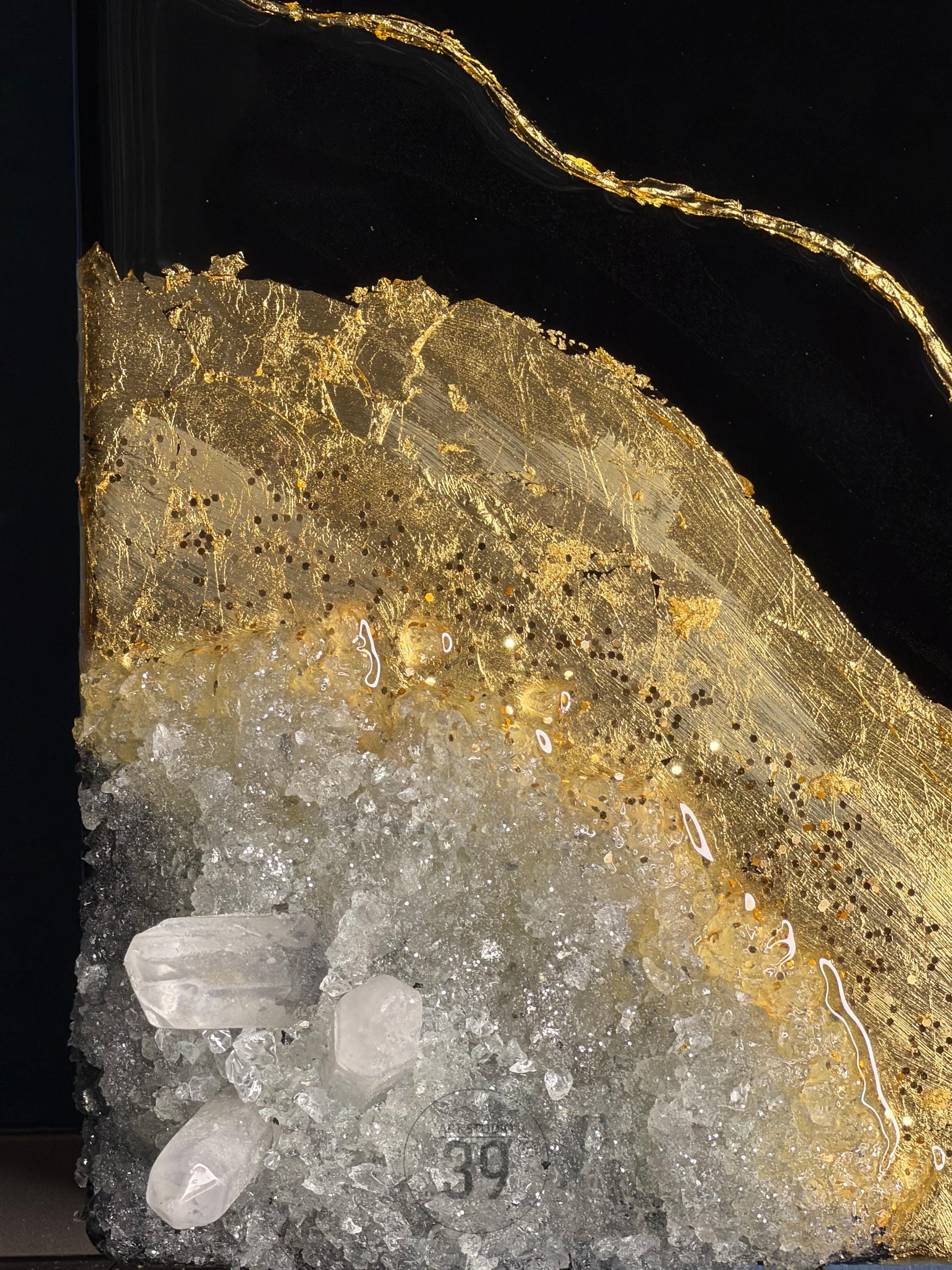 Abstract art piece featuring a black background with a gold leaf design. The artwork incorporates clear quartz crystals and glitter accents. The piece has a layered texture and a modern aesthetic.