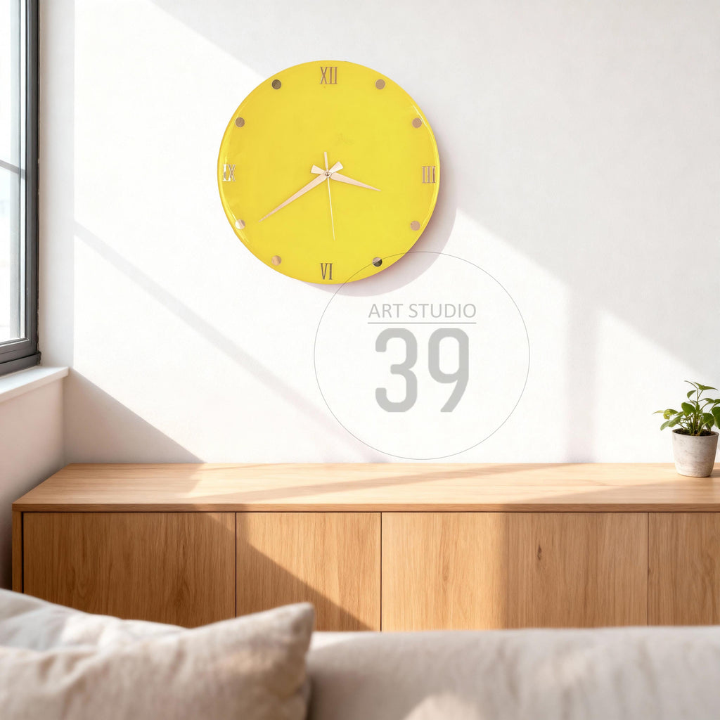 A round, yellow wall clock with Roman numerals and gold-colored accents. The clock hands are white. The clock is mounted on a white wall. The image also includes the text "ART STUDIO 39".