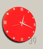 A round, red wall clock with white Roman numerals and hands. White dots mark the hours. The clock face has a glossy finish. The clock is a decorative item for home decor.