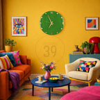 A vibrant living room with a yellow wall, featuring a green clock, colorful artwork, and an orange sofa with patterned pillows. A blue coffee table holds flowers and cups, creating a lively and artistic space.