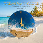 Ocean-themed wall clock with a blue and gold design. The clock face features a depiction of ocean waves and sand, with gold Roman numerals and hands. The clock is available in 40, 50, and 60 cm sizes.
