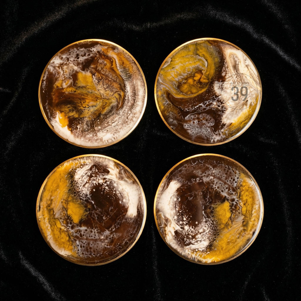 Set of four round coasters with a gold rim. The coasters feature a swirling design in shades of brown, yellow, and white. One coaster has the number "39" printed on it. The coasters are displayed on a black surface.