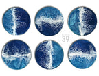 Set of six round coasters with a resin ocean wave design. The coasters feature shades of blue and white, with a glossy finish. The text "ART STUDIO 39" is in the center.