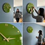 A round, green wall clock with gold-colored Roman numerals and hands. The clock is mounted on a blue wall. The clock's face is a solid, glossy green color. The clock is a decorative item for home decor.