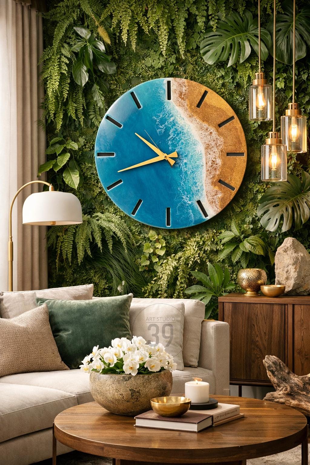 A large, round wall clock with a beach-themed design. The clock face features a blue ocean and sandy shore, with gold-colored hands and hour markers. The clock is mounted on a green wall of plants, creating a natural aesthetic.