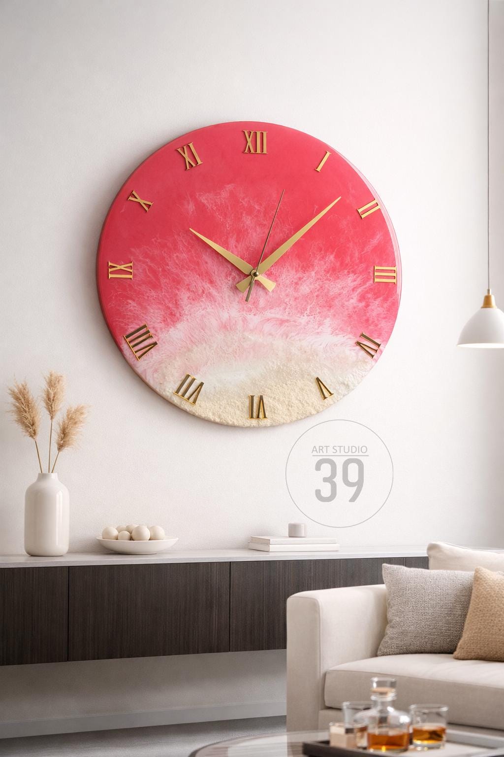 A large, round wall clock with a coral and white resin design. The clock features gold Roman numerals and hands. The clock is mounted on a white wall, with a modern interior design.