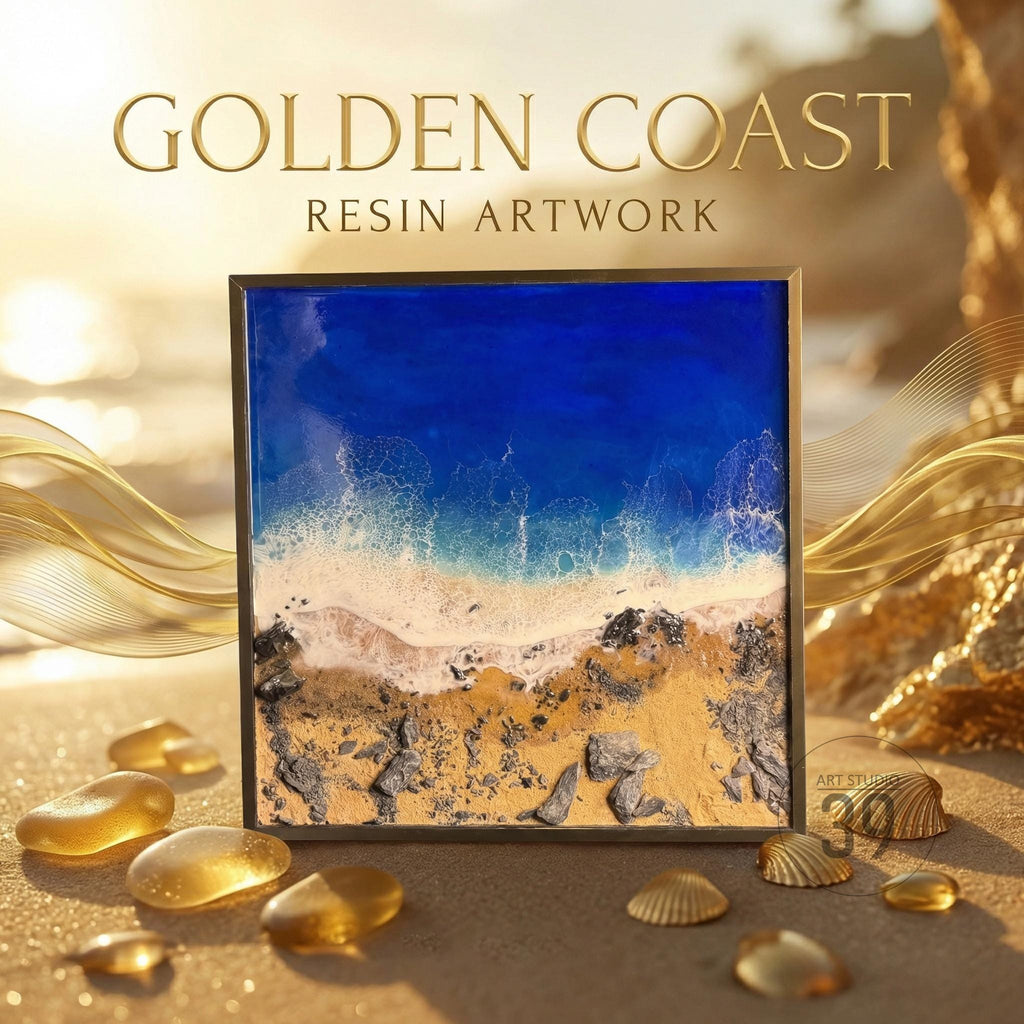 Square resin artwork titled "Golden Coast" depicts a beach scene with a blue ocean, white waves, and golden sand. The artwork is framed in a dark metal frame. The artwork is surrounded by golden decorative elements and seashells.