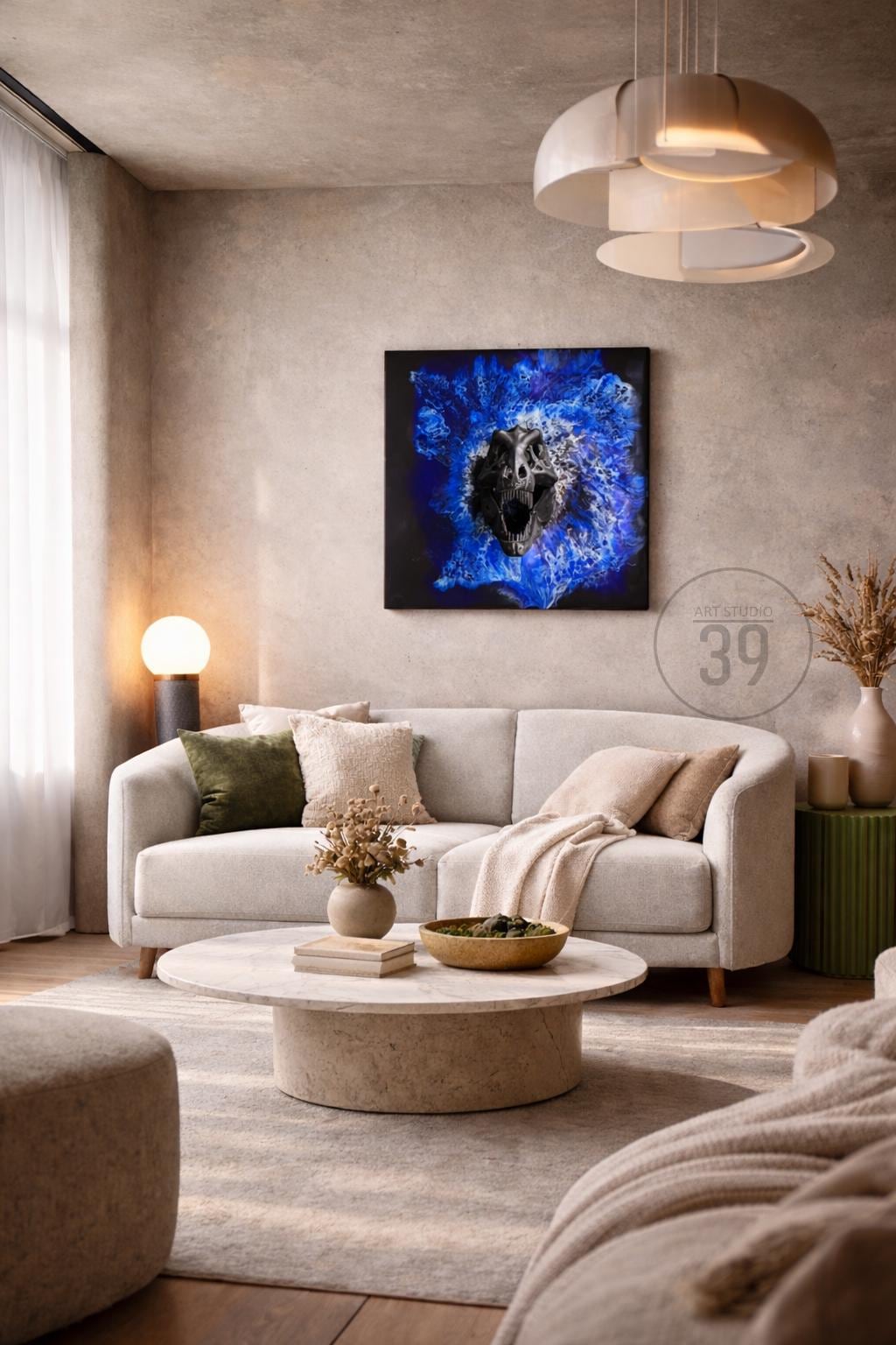 A modern living room with a light gray sofa, a round coffee table, and a large artwork featuring a dinosaur skull against a blue background. The room is decorated with neutral tones and includes decorative pillows and a rug.