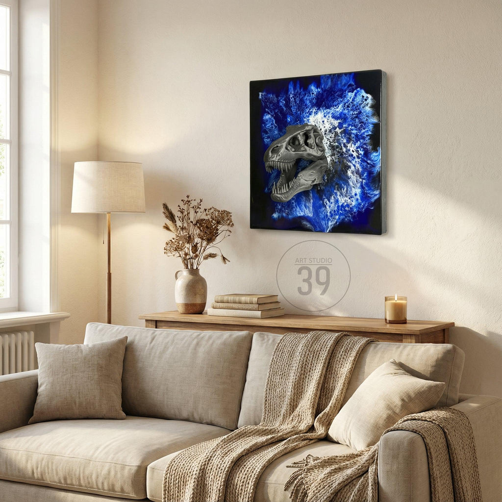 A framed canvas art piece featuring a dinosaur skull with a blue and white abstract background. The artwork is displayed on a beige wall above a wooden console table. The text "ART STUDIO 39" is visible.
