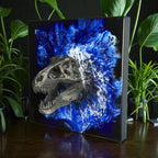 A silver-colored Tyrannosaurus Rex skull sculpture against a blue and white abstract background. The artwork is mounted on a black square canvas. The text "ROUTE STUDIO 39" is visible on the lower right corner.