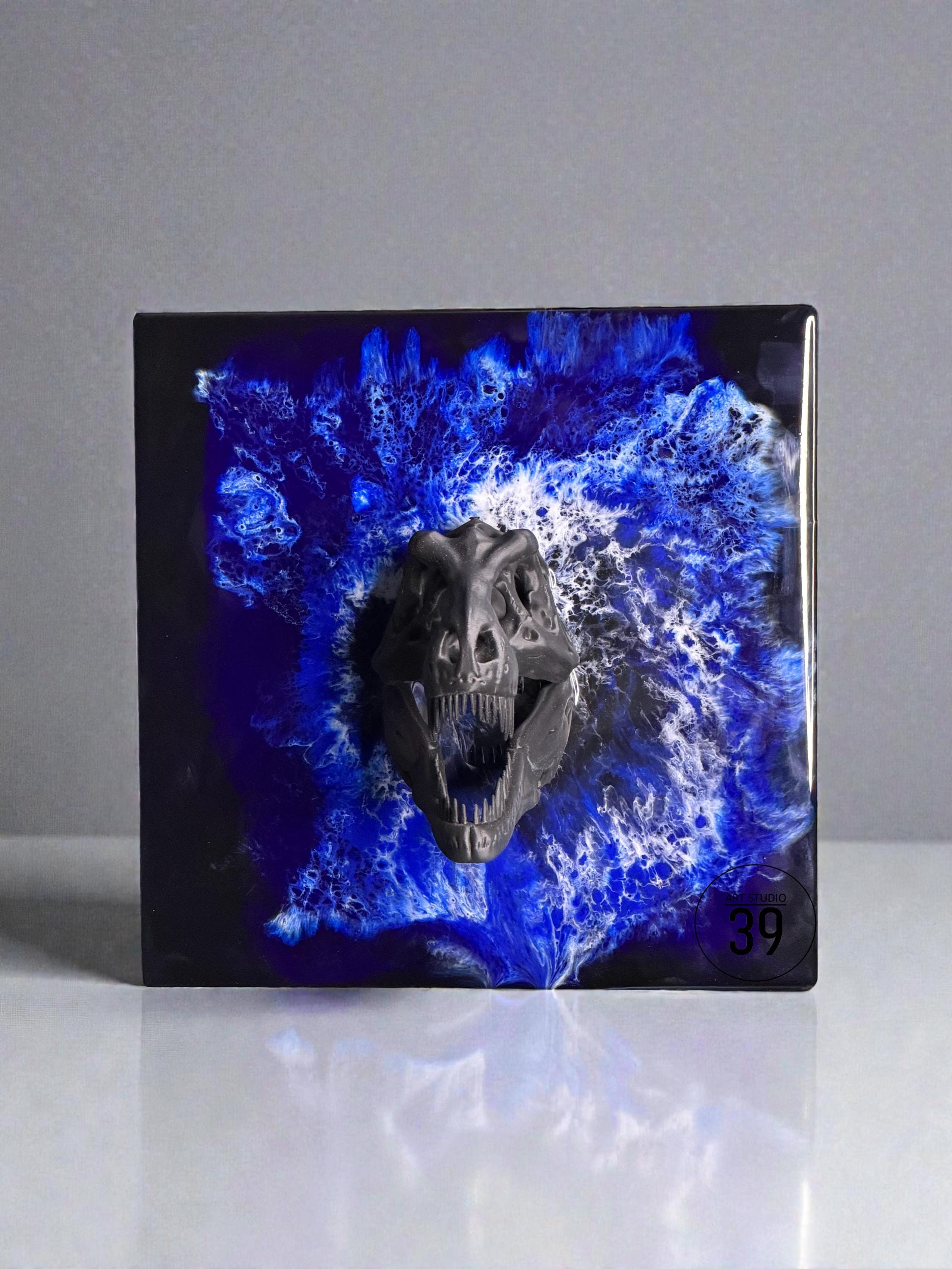 A square, dark artwork featuring a detailed, dark gray dinosaur skull emerging from a vibrant blue and white abstract design. The number "39" is visible in the lower right corner. The artwork has a glossy finish.