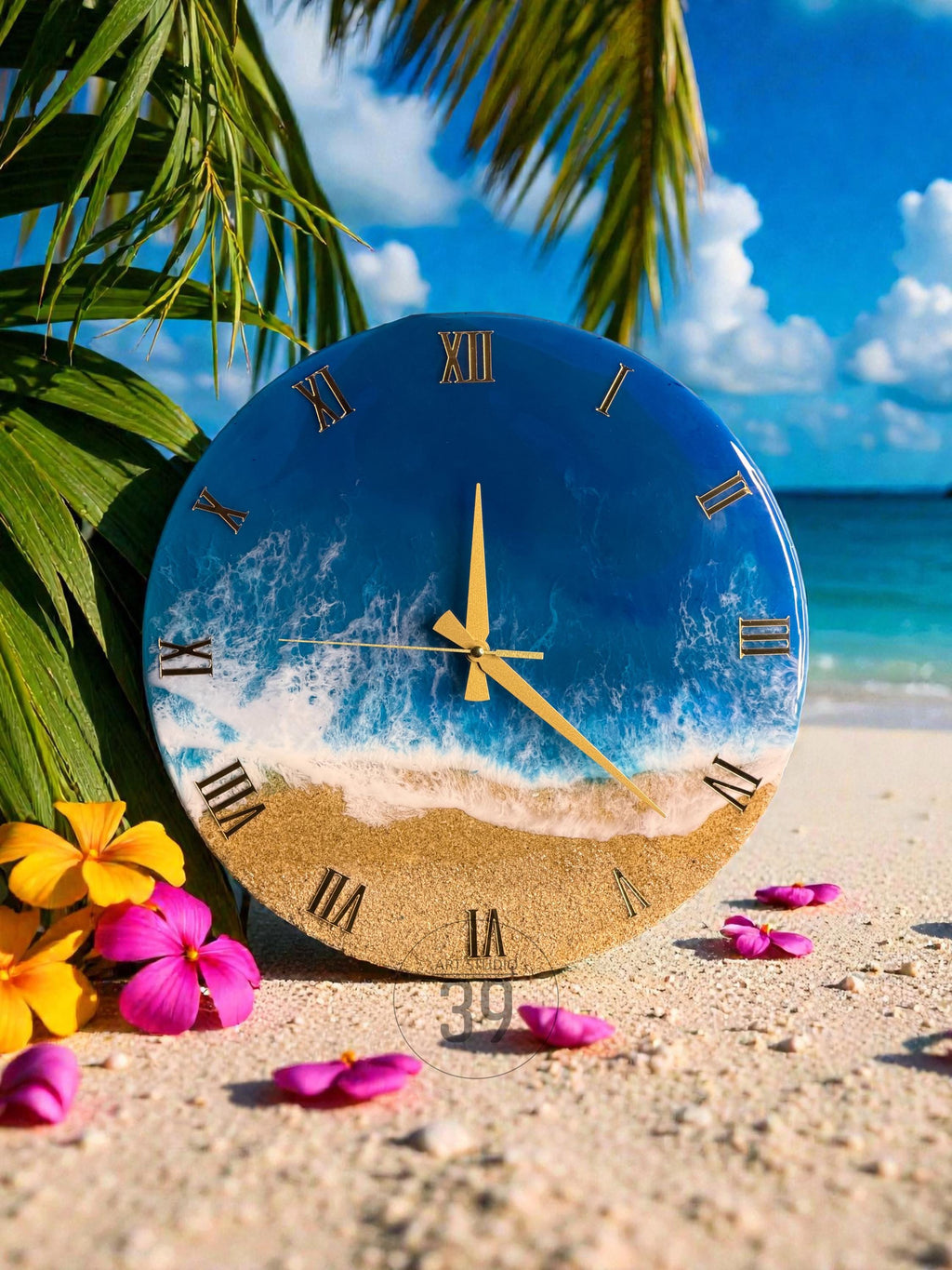Round wall clock with a beach scene design. The clock face features a blue ocean, white waves, and a sandy beach. Gold Roman numerals and clock hands complete the design. The clock is surrounded by palm leaves and flowers.