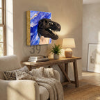 A black Tyrannosaurus Rex skull sculpture emerging from a blue and gold abstract art piece. The artwork is mounted on a wall, with a wooden console table and a small potted plant below.