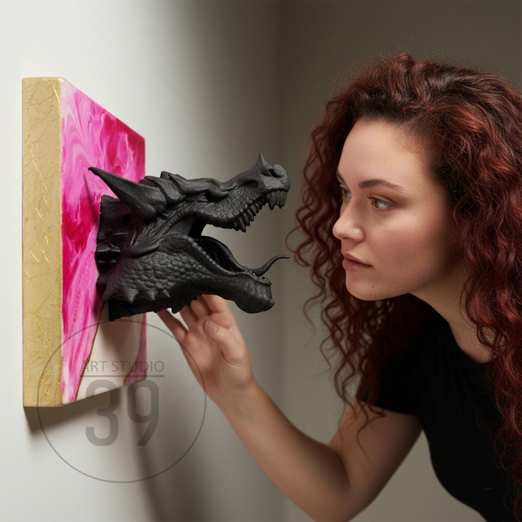 A black dragon head sculpture emerging from a pink and white abstract painting. The artwork is mounted on a wooden frame. The text "ART STUDIO 39" is visible on the painting.