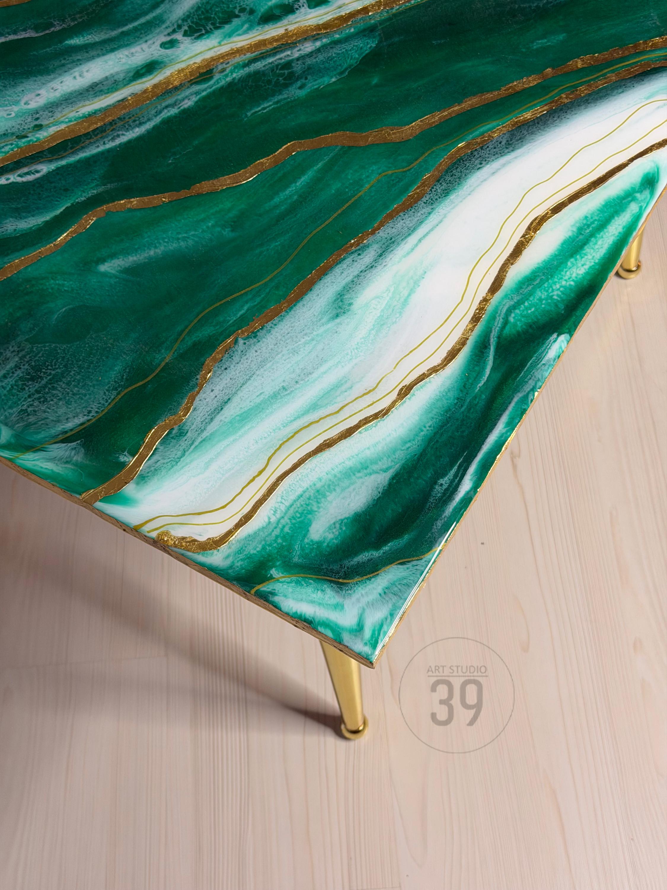 A rectangular coffee table with a green and white marbled design, accented with gold lines. The table has gold legs and the text "ART STUDIO 39" is visible on the side.