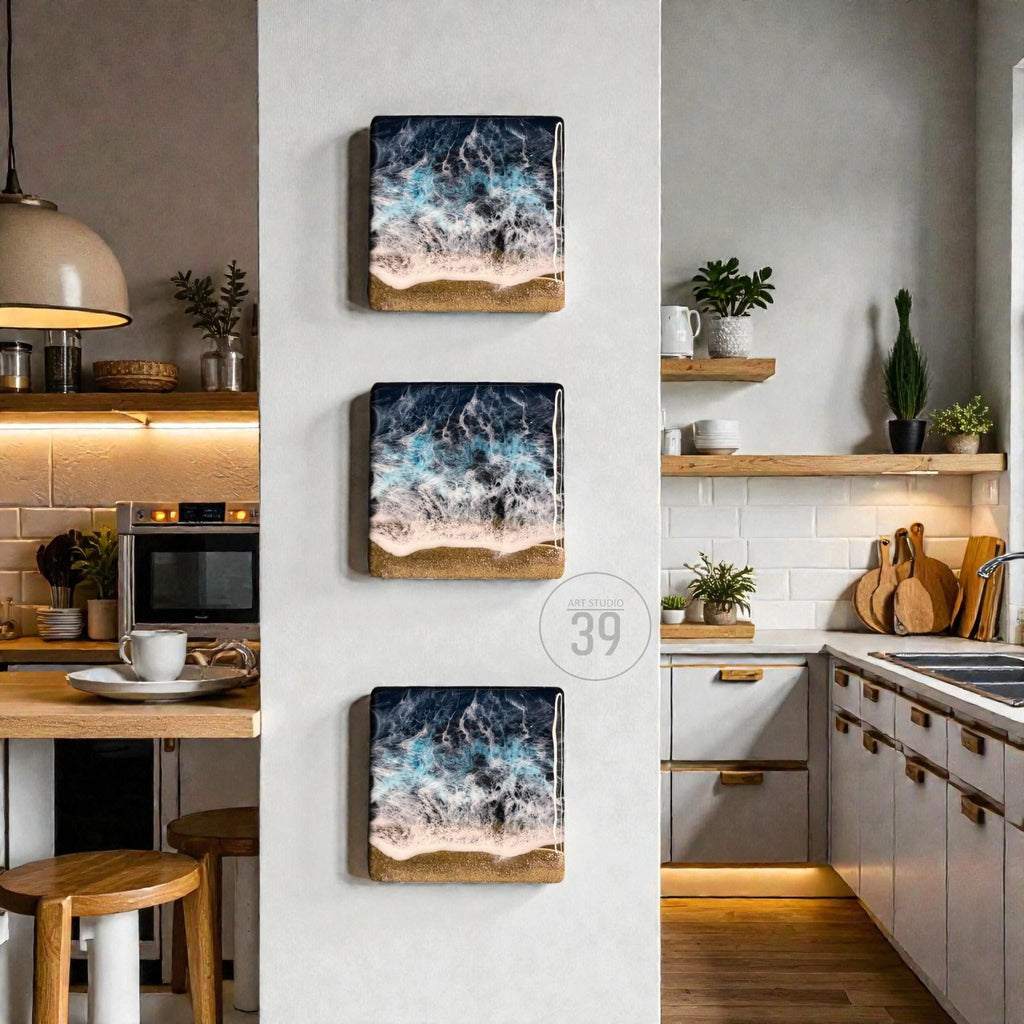 Three square wall art pieces depicting an ocean scene with dark blue and white waves crashing onto a sandy beach. The art is framed with a light brown border and mounted on a white wall. The number "39" is in a circle.
