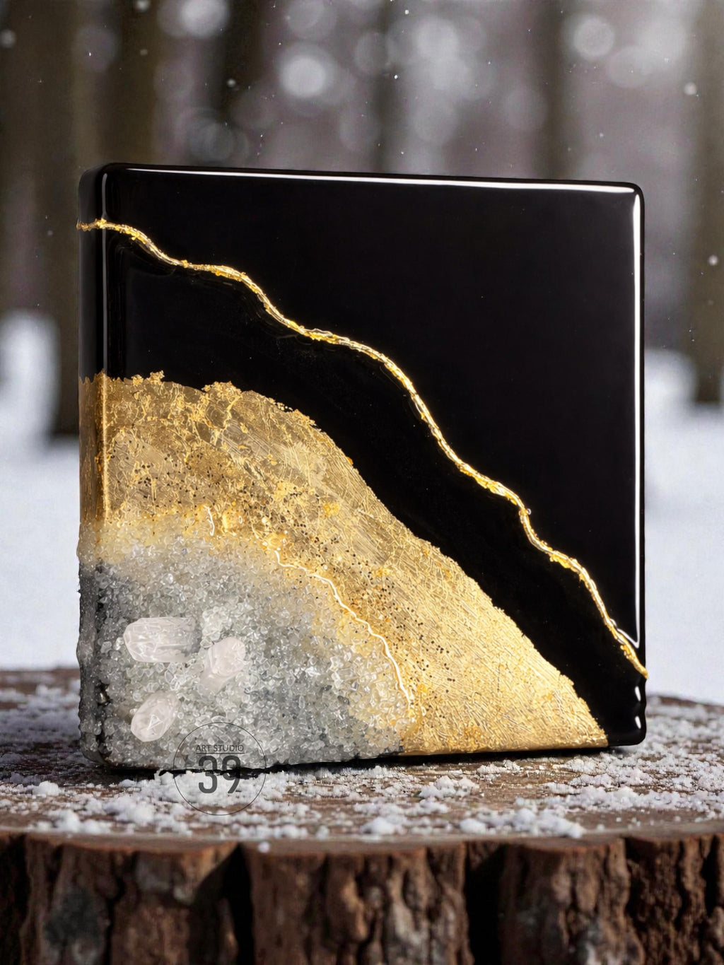 A square, black resin art piece with a gold vein design. The bottom half features a textured, gold and white crystal formation. The piece is displayed on a wooden surface, showcasing a unique blend of materials and textures.
