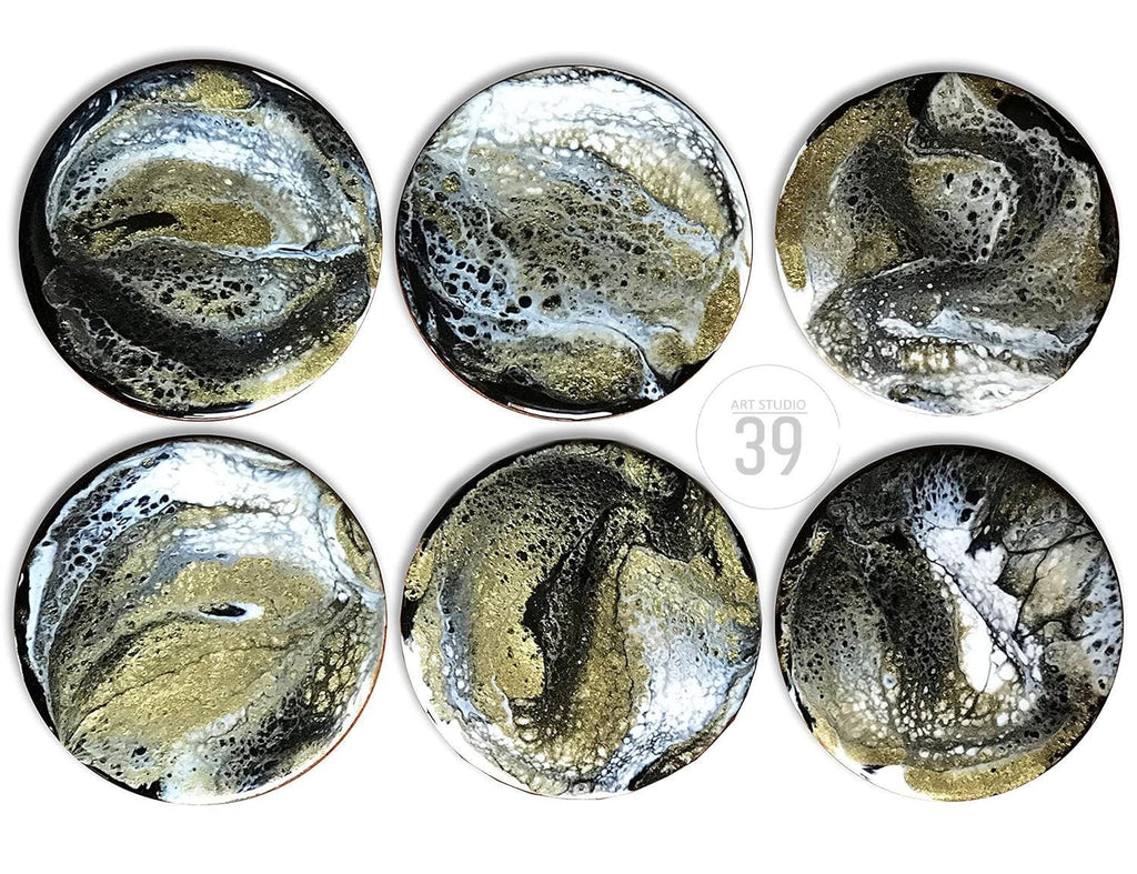 Six round coasters with an abstract design in black, gold, and white. The coasters have a glossy finish and a unique, fluid pattern. The text "ART STUDIO 39" is in the center. These coasters are perfect for adding a touch of modern art to any home.
