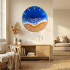 A round wall clock with a beach scene design. The clock face features a blue ocean, a sandy beach, and gold-colored clock hands. The clock is mounted on a white wall. The text "ART STUDIO 39" is in the lower center.