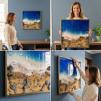 Square framed artwork depicting a beach scene with a vibrant blue ocean, white foamy waves, and golden sand. The artwork includes dark gray rocks and a gold-colored frame. The art is displayed on a blue wall.