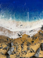 Abstract resin art depicting a beach scene. The artwork features a deep blue ocean, foamy white waves, and a sandy shore with dark gray rocks. The text "39" is visible in the image.