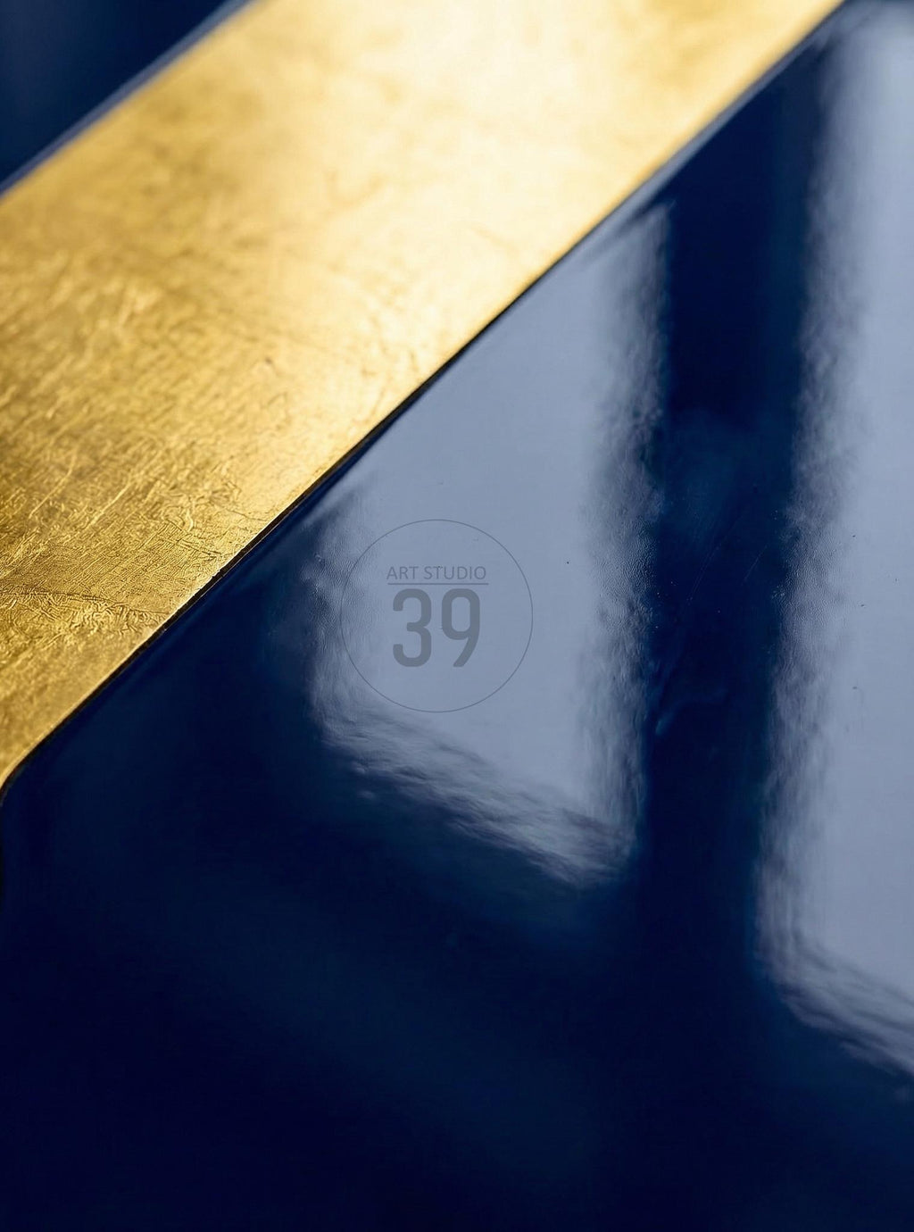 Abstract art piece with a diagonal gold leaf accent against a dark blue background. The image features a glossy finish and the text "ART STUDIO 39" in a circular design.