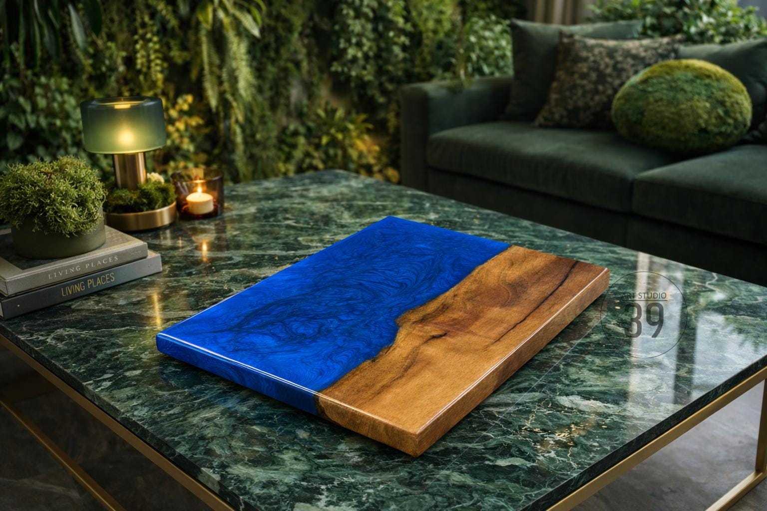 A rectangular wooden serving board with a vibrant blue resin section and a natural wood grain section. The board is displayed on a green marble coffee table, showcasing a modern design aesthetic.