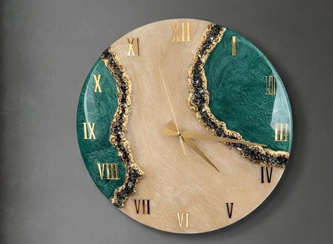 A round wall clock featuring a beige center with a swirling pattern, flanked by two deep green sections. The clock face includes gold Roman numerals and gold hands, with textured black and gold crystalline accents separating the colors.