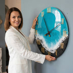 A round wall clock with a blue and white ocean-themed design. The clock features gold Roman numerals and hands, with the number 39 in the center. The clock is held against a blue wall.
