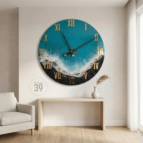 Large round wall clock with a teal and black ocean-themed design. The clock features gold Roman numerals and hands. The clock face has a wave-like pattern with white and black accents. The text "ART STUDIO 39" is visible.