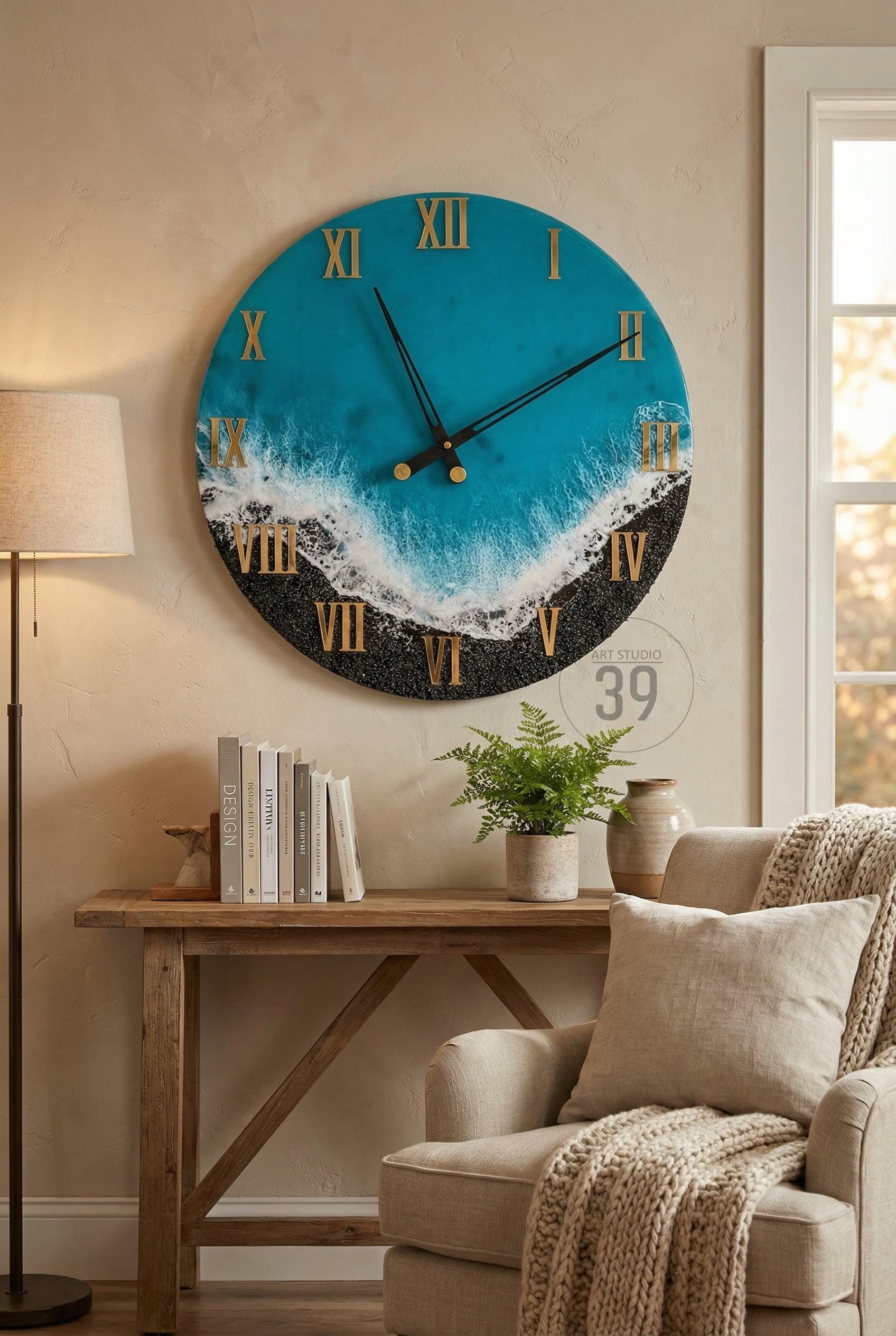 Large round wall clock with a blue and black ocean-themed design. The clock face features gold Roman numerals and hands. The clock is mounted on a beige wall above a wooden table.