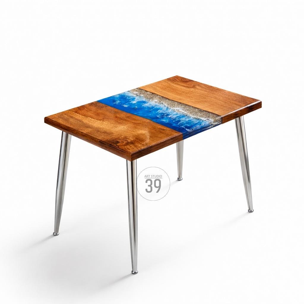 A rectangular wooden table with a blue and white resin design resembling ocean waves. The table has a natural wood grain finish and sits on four chrome legs. The table is approximately 30 inches long.