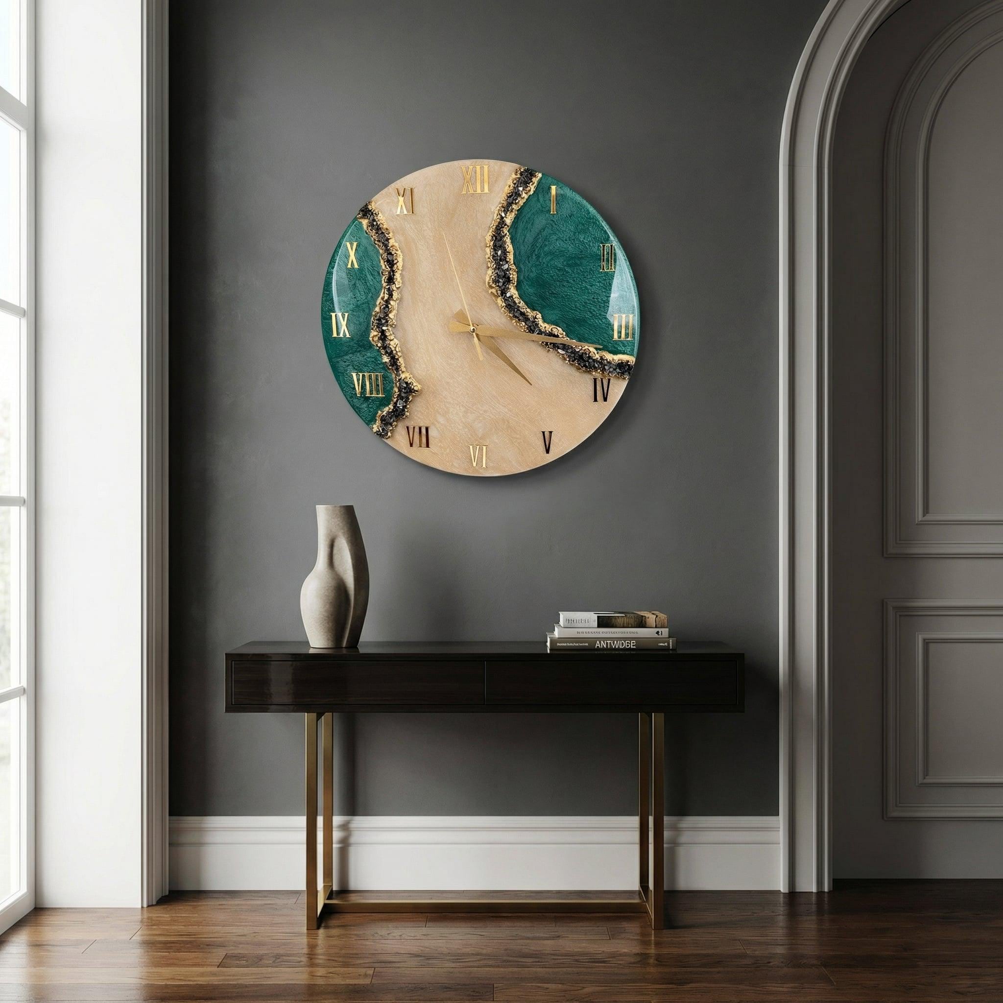 A circular wall clock featuring a light wood grain center contrasted by deep emerald green resin sections on the sides. The clock face displays gold Roman numerals and thin gold hands, with textured black and gold detailing along the resin edges.