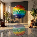 A large, round wall clock with a vibrant rainbow design. The clock features white hands and Roman numerals, adding a classic touch to the colorful artwork. The clock is mounted on a dark gray wall.
