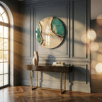 A large circular wall clock featuring a cream-colored face with teal resin accents and gold-toned Roman numerals. The clock has thin gold hands and a textured, geode-inspired design running diagonally across the center of the dial.
