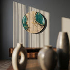 A round wall clock featuring a beige center with two dark green, textured resin sections on the sides. The clock face includes gold Roman numerals and thin gold hands. The design mimics a geode with gold-toned edges along the green areas.