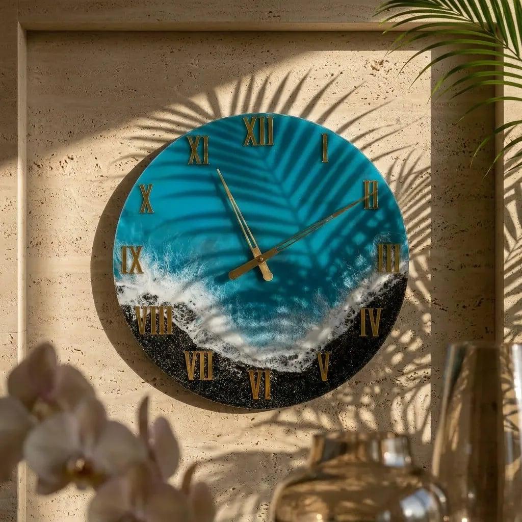 Round wall clock with a blue and white ocean-themed design. The clock face features gold Roman numerals and hands, with a palm leaf pattern. The clock is mounted on a beige wall.