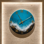 Round wall clock with a blue and white ocean wave design. The clock face features gold Roman numerals and gold hands. The clock is mounted on a beige wall.