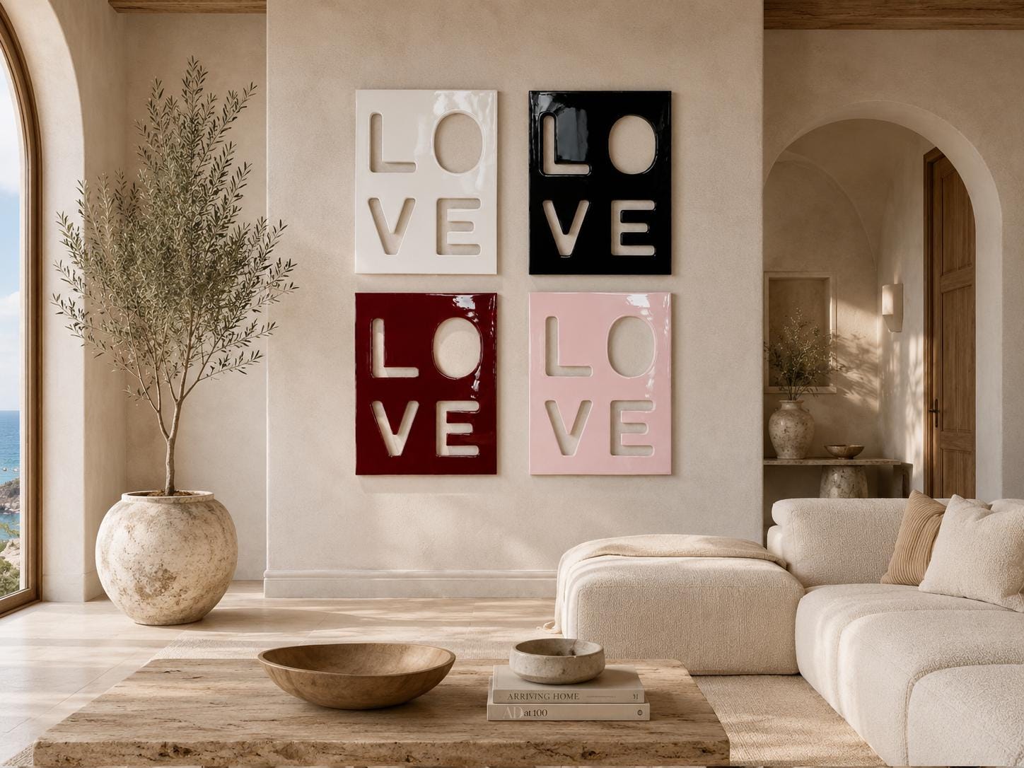 Four square wall art panels arranged in a grid, each featuring the word LOVE in a cutout style. The top left panel is white, the top right is black, the bottom left is deep red, and the bottom right is light pink, all with a glossy finish.