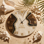 A round wall clock with a white and brown marbled surface, featuring gold Roman numerals and black clock hands. A central band of black crushed stone accents the face, which displays the text YASIN KAZDAL in gold lettering.
